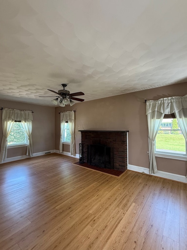 922 W Lockhart St, Sayre, PA 18840 - unfurnished living room with wood finished floors, a brick fireplace, and ceiling fan
