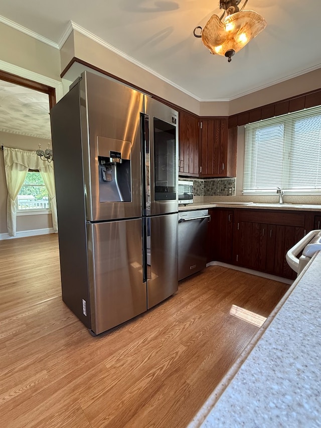 922 W Lockhart St, Sayre, PA 18840 - kitchen with stainless steel appliances, light countertops, light wood finished floors, dark brown cabinetry, and crown molding