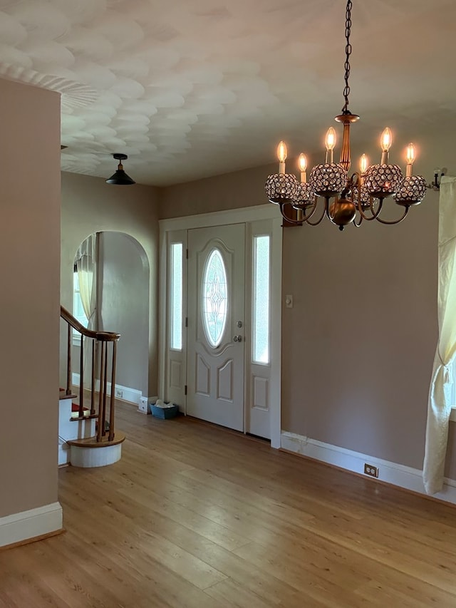 922 W Lockhart St, Sayre, PA 18840 - foyer entrance with arched walkways, wood finished floors, stairs, and a chandelier