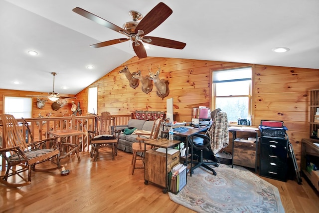 office area with lofted ceiling, a wealth of natural light, light wood-style flooring, and wooden walls