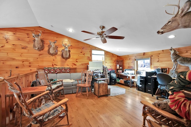 home office with lofted ceiling, ceiling fan, wood walls, and wood finished floors