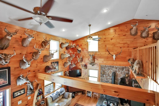 interior space with plenty of natural light, vaulted ceiling, and wood walls