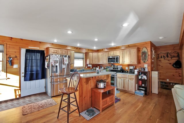 kitchen featuring wooden walls, appliances with stainless steel finishes, light countertops, light wood-style floors, and open shelves