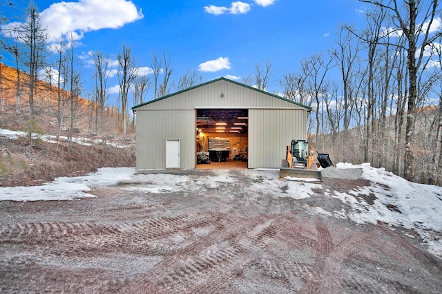 snow covered garage featuring a detached garage