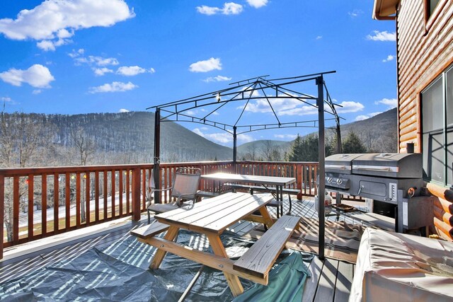 wooden deck with outdoor dining space and a mountain view