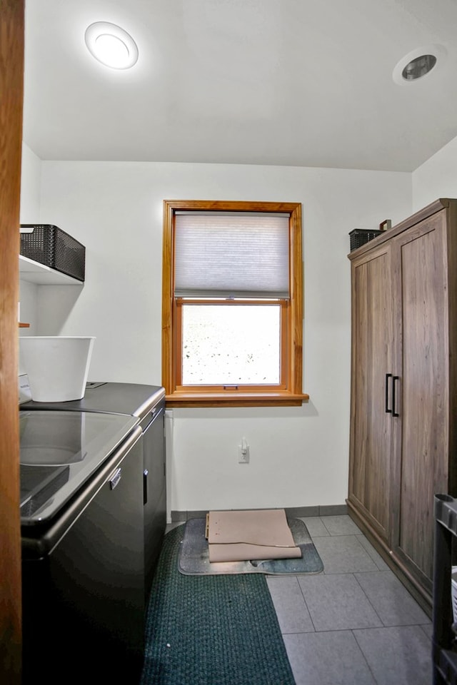 washroom featuring tile patterned flooring, laundry area, baseboards, and separate washer and dryer