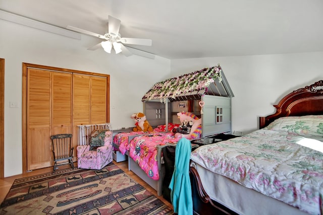 bedroom featuring vaulted ceiling, a closet, wood finished floors, and a ceiling fan