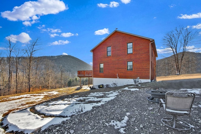 view of snow covered exterior with a fire pit and a mountain view