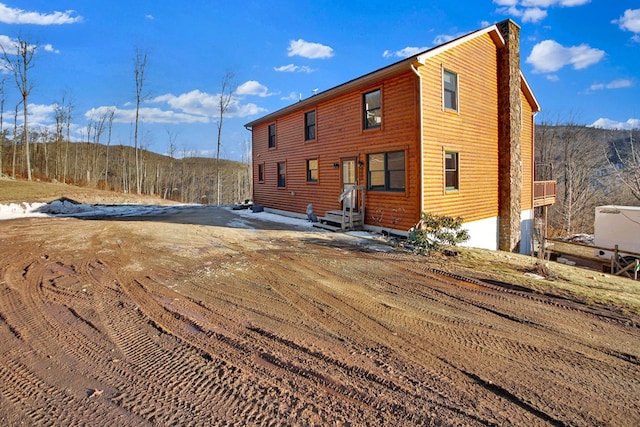 back of house featuring faux log siding