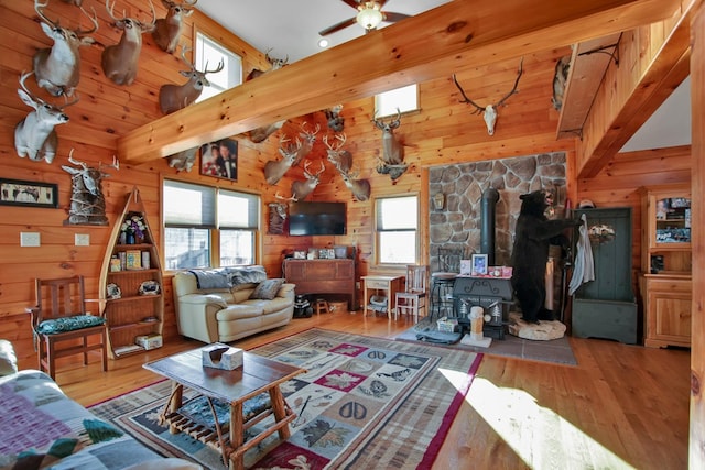 living area featuring wood finished floors, a wood stove, and wooden walls