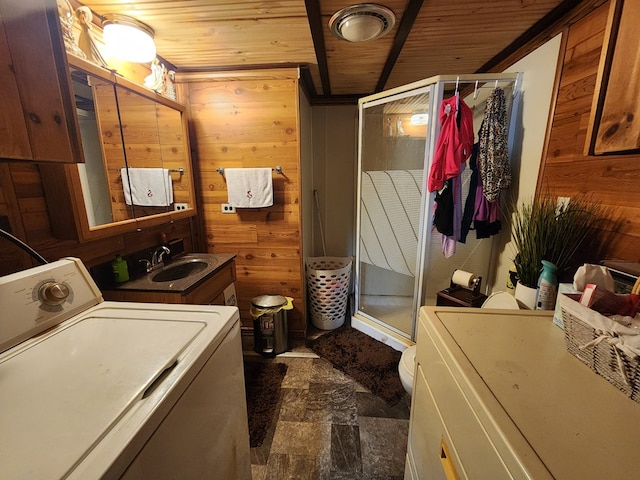 bathroom with vanity, wooden walls, wooden ceiling, washer / clothes dryer, and a shower with shower door