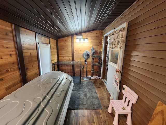 bedroom with dark hardwood / wood-style flooring, lofted ceiling, wooden ceiling, and wooden walls