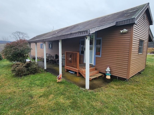 rear view of property featuring a lawn