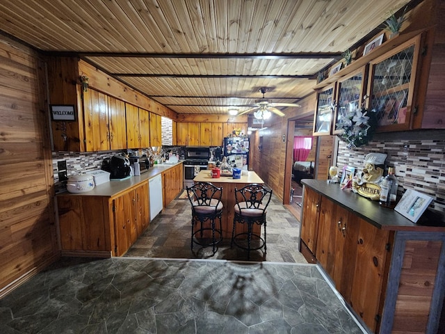 kitchen with ceiling fan, black fridge, white dishwasher, a kitchen island, and wood ceiling