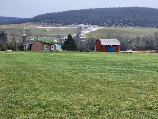 view of yard with a mountain view, a rural view, and an outdoor structure