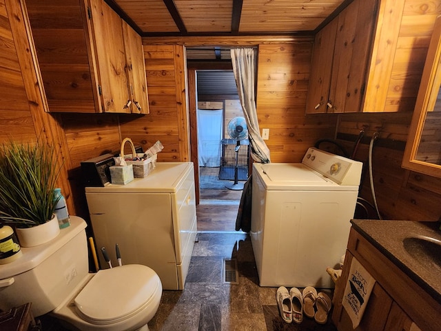 washroom with washer and dryer, wood ceiling, and wood walls