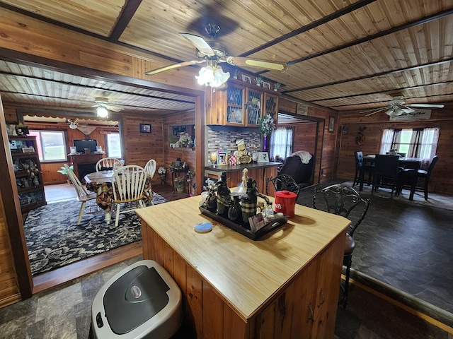 dining area featuring a wealth of natural light, wood ceiling, and wood walls