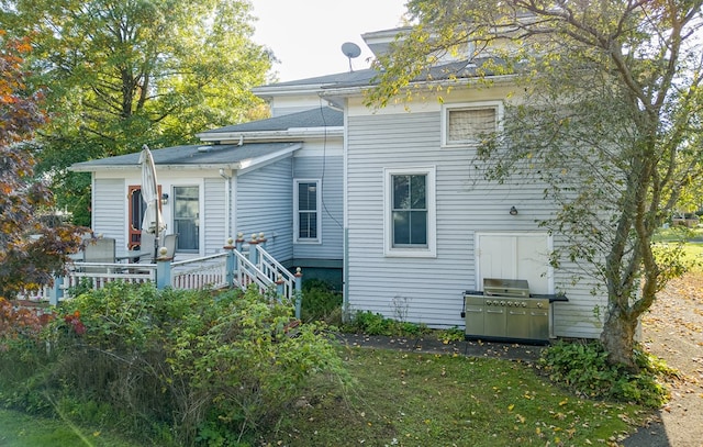 rear view of property featuring a lawn and a wooden deck