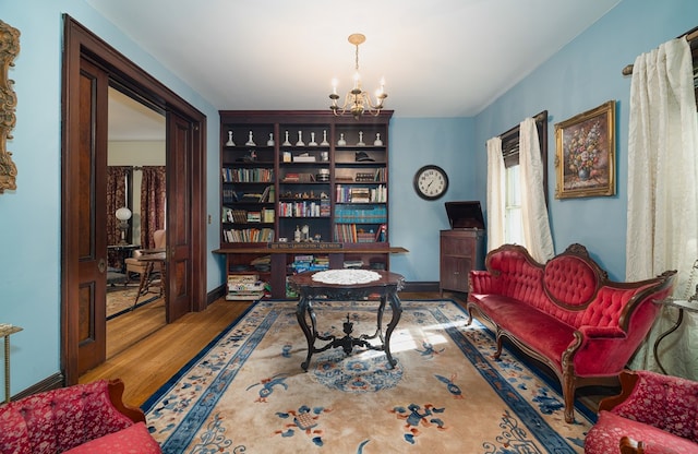 living area featuring hardwood / wood-style floors and a notable chandelier