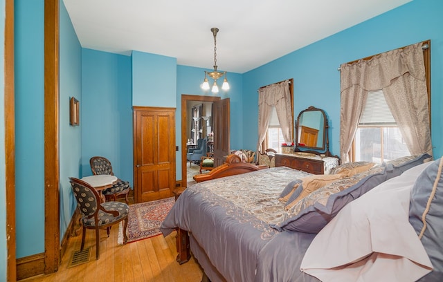 bedroom with hardwood / wood-style flooring and a chandelier