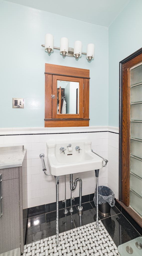 bathroom with sink and tile walls