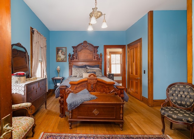 bedroom with a chandelier and light hardwood / wood-style floors