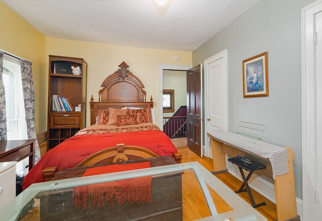 bedroom with hardwood / wood-style floors and multiple windows