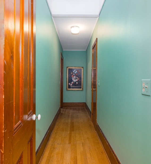 corridor featuring light hardwood / wood-style floors and crown molding