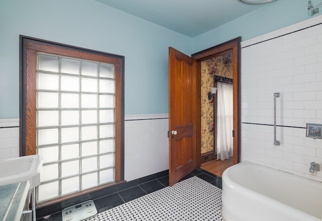 bathroom featuring tile patterned flooring, tile walls, and a tub