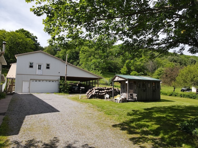 view of side of home with a carport, a garage, and a yard