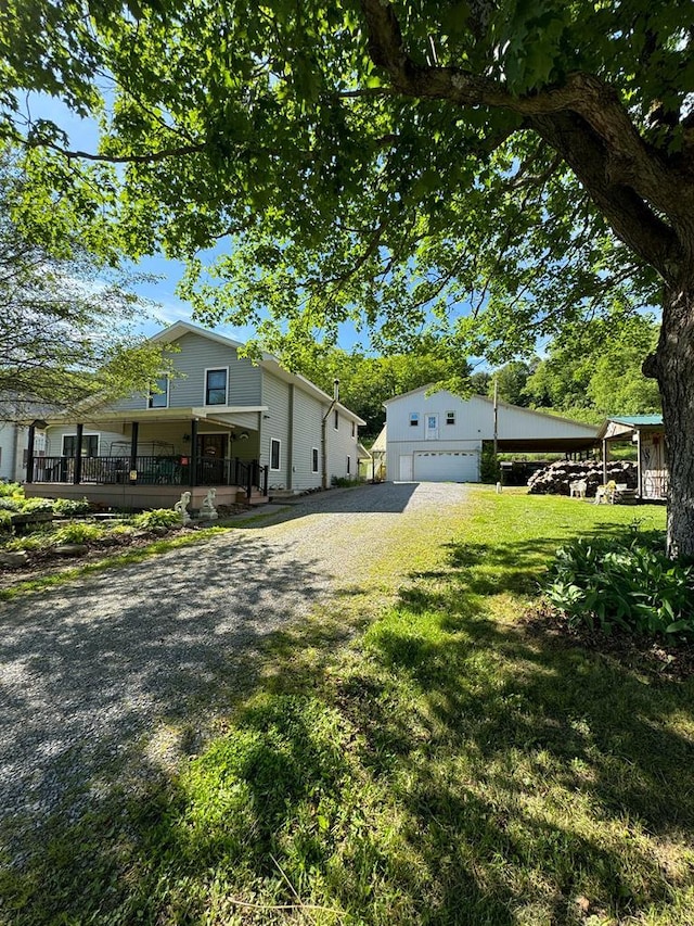 view of side of property featuring a porch, a garage, and a lawn