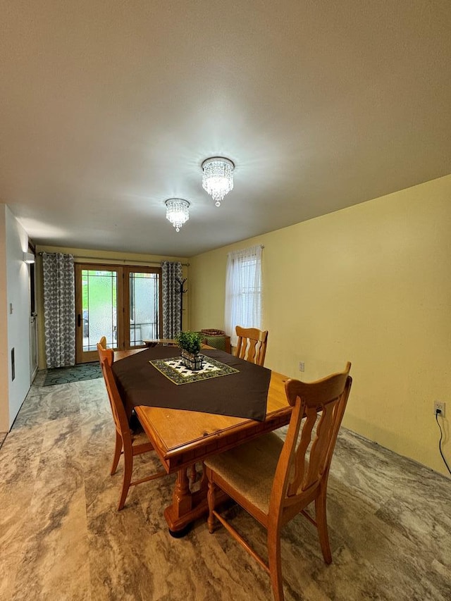 dining area with carpet flooring, french doors, and an inviting chandelier