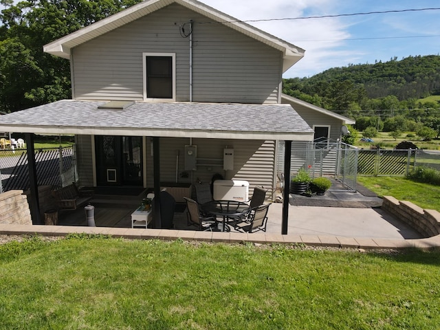 rear view of house with a lawn and a patio area