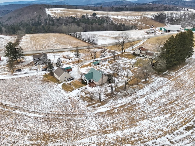 snowy aerial view featuring a rural view and a mountain view