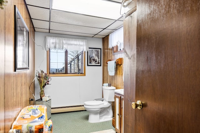 bathroom with toilet, baseboard heating, and a drop ceiling