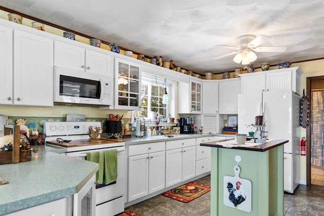 kitchen featuring ceiling fan, white appliances, white cabinets, a center island, and glass insert cabinets