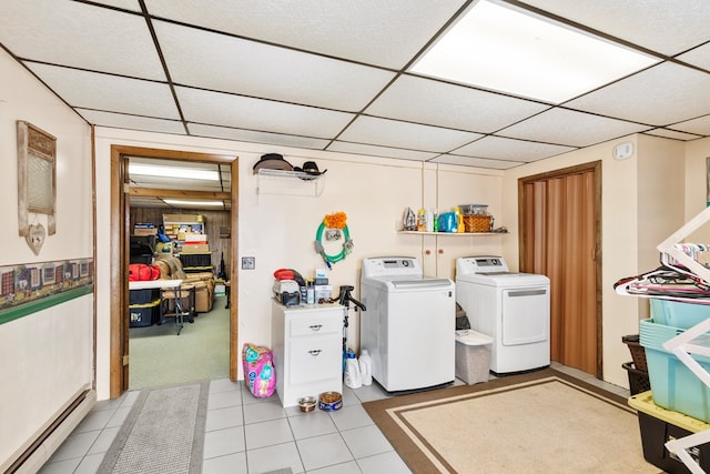 laundry area featuring a baseboard heating unit, washer and dryer, laundry area, and light tile patterned flooring