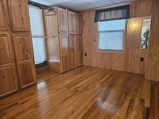 unfurnished bedroom with hardwood / wood-style floors and wooden walls