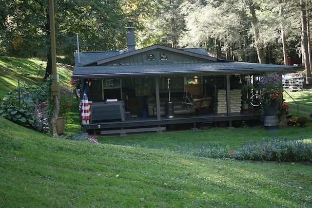 rear view of house with a lawn and a deck