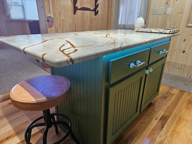 interior space featuring tile counters, light hardwood / wood-style floors, and green cabinetry