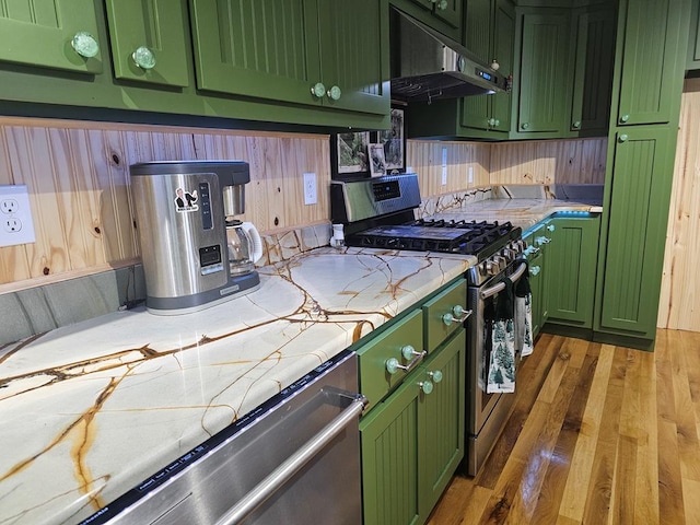 kitchen with light stone counters, stainless steel appliances, dark hardwood / wood-style floors, and green cabinets