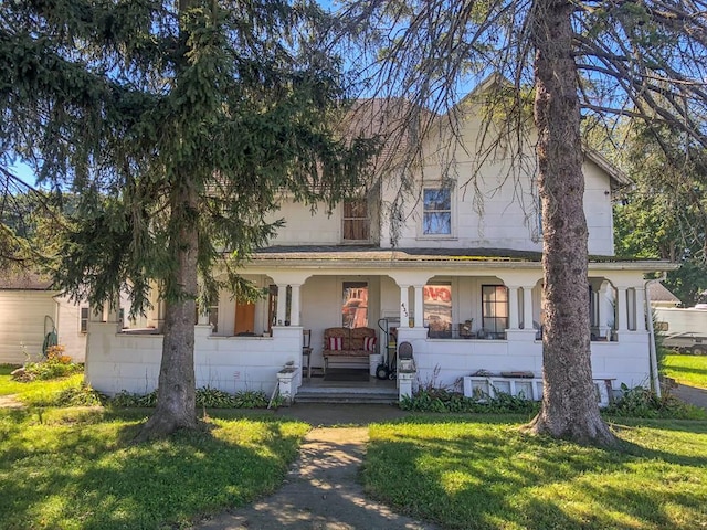 view of front of house with a porch and a front yard