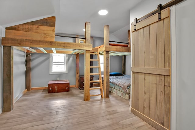 658 Ashley Hill Rd, Mansfield, PA 16933 - unfurnished bedroom with a barn door and light wood-style flooring