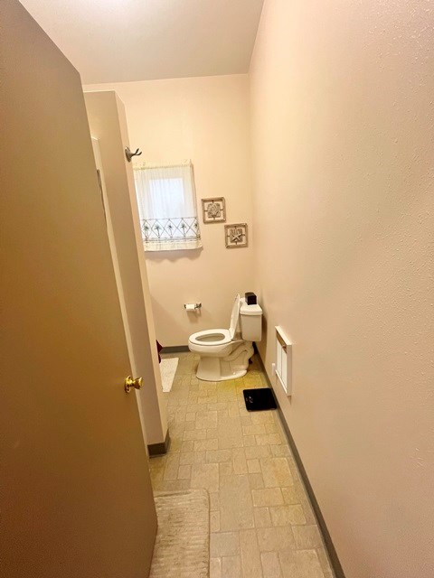 bathroom featuring visible vents, toilet, and baseboards