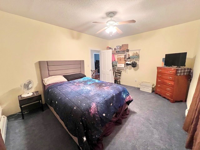 bedroom featuring carpet floors, ceiling fan, a textured ceiling, and baseboard heating