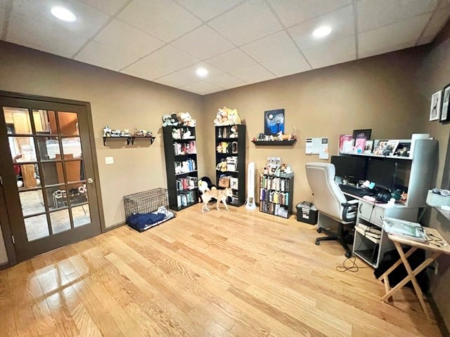 office area with a drop ceiling and wood finished floors