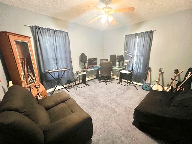 home office featuring a textured ceiling, carpet floors, and ceiling fan