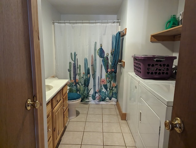 bathroom with toilet, vanity, tile patterned floors, and washing machine and clothes dryer