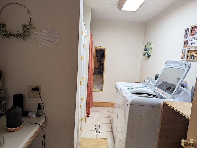 clothes washing area featuring washing machine and clothes dryer and light tile patterned floors