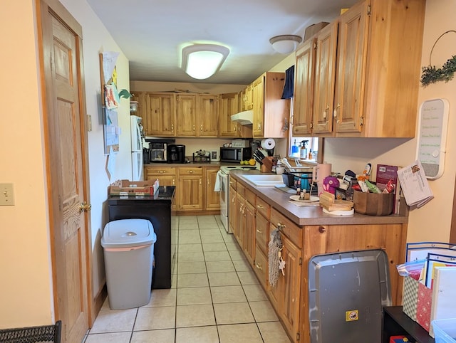 kitchen with sink, light tile patterned floors, and white appliances